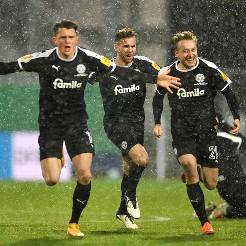 Spieler von Holstein Kiel laufen jubelnd auf die Kamera zu