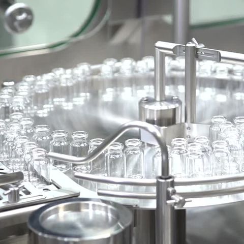 Auf einer runden Edelstahl-Abfüllanlage kreisen leere Ampullen für den Corona-Im pfstoff von Biontech