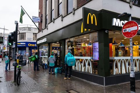 Eine Gruppe von Lieferfahrern wartet vor einem McDonalds in Peckham, Südlondon
