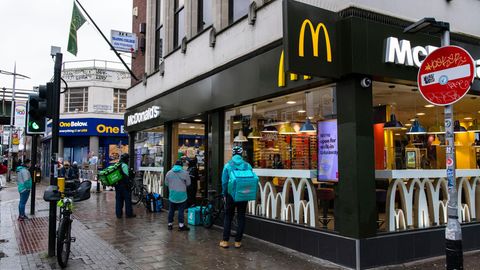 Eine Gruppe von Lieferfahrern wartet vor einem McDonalds in Peckham, Südlondon